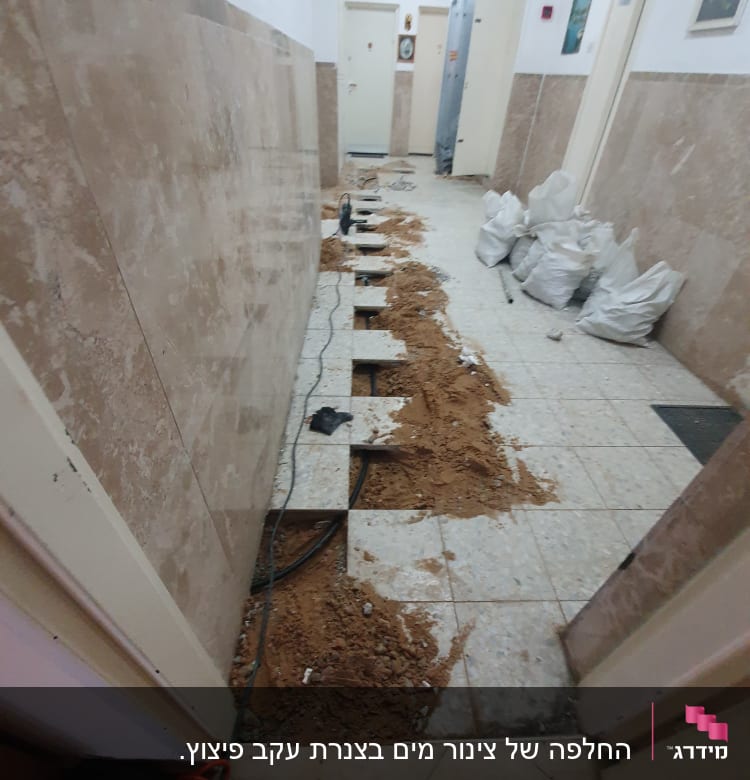 חפירה ברצפה עם כבלים וכלי עבודה במסדרון